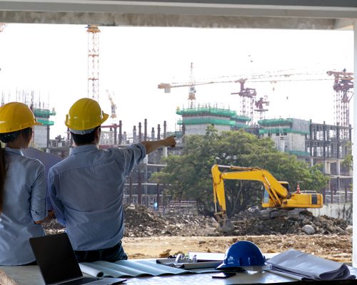 Engineer group and worker meeting, discussion with construction blueprint on site work and point finger to the work site